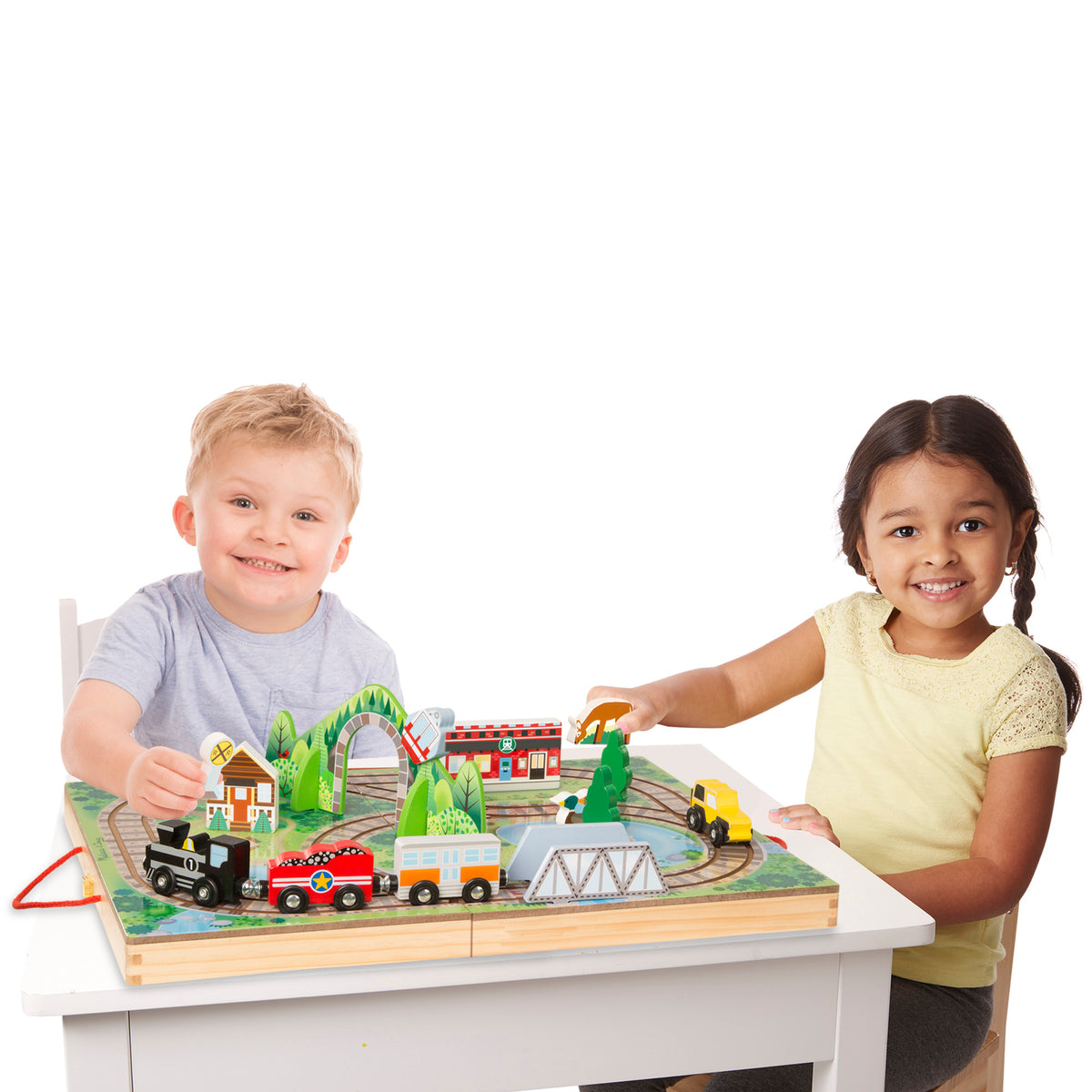 Melissa & Doug wooden train set with colorful cars, tracks, and buildings on play case