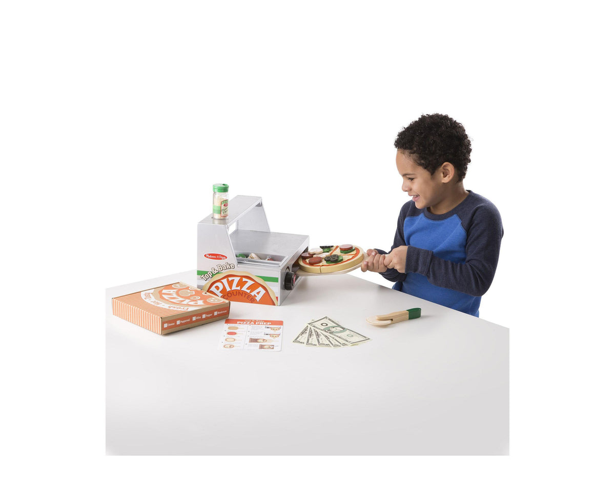 Melissa & Doug Top & Bake Wooden Pizza Counter Play Set with child making pizza at counter, includes play money and p...