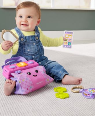 Fisher-Price Laugh & Learn On-the-Go Learning Purse in pink with toddler playing with included accessories
