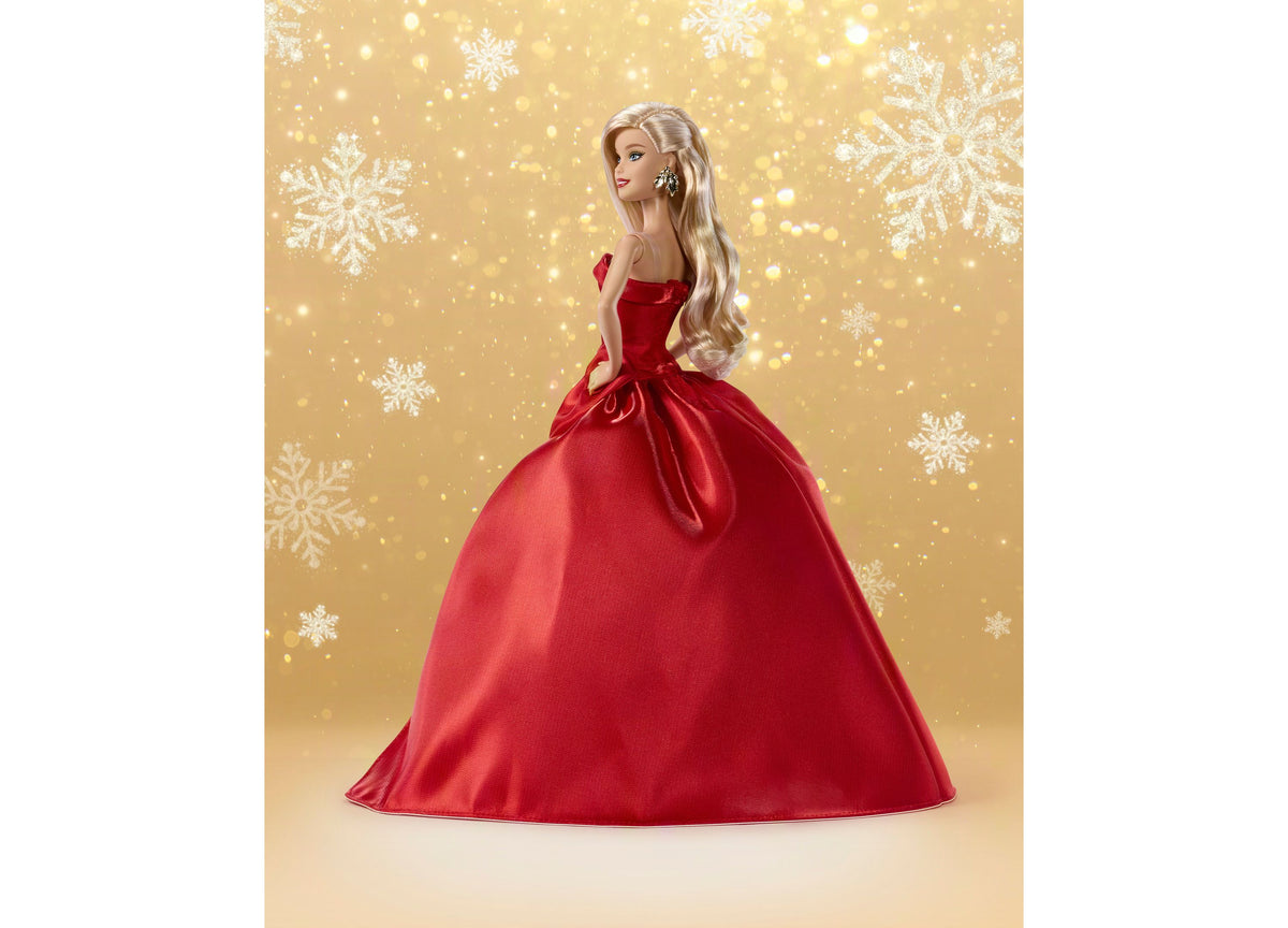 Holiday Barbie doll in red strapless gown with bow detail and full skirt against gold snowflake background