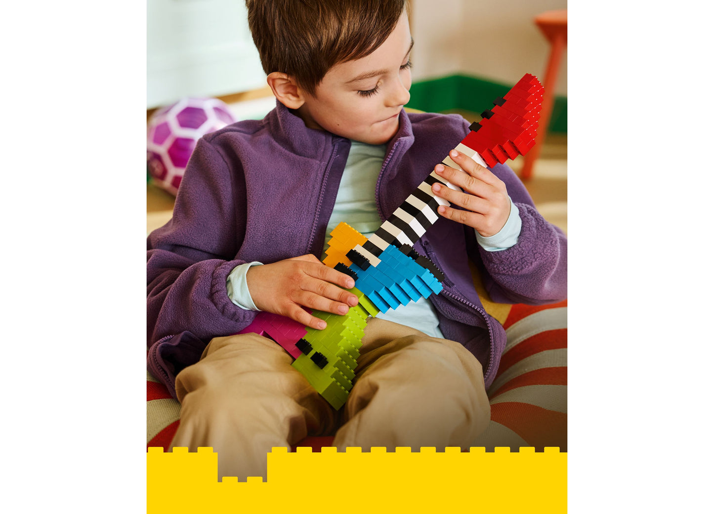 Child playing with LEGO Classic Creative Colorful Bricks 11045 set featuring red, blue, yellow, and green bricks