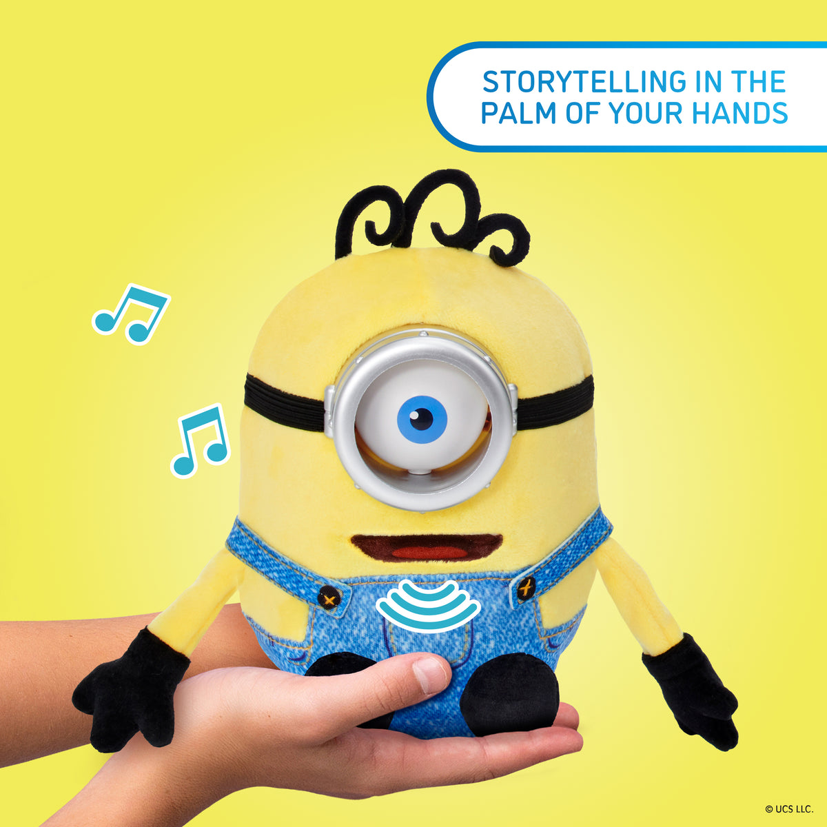 WOW! Stuff Minions Palm Puppetronic James toy held in palm of hand, yellow character with blue overalls on yellow bac...