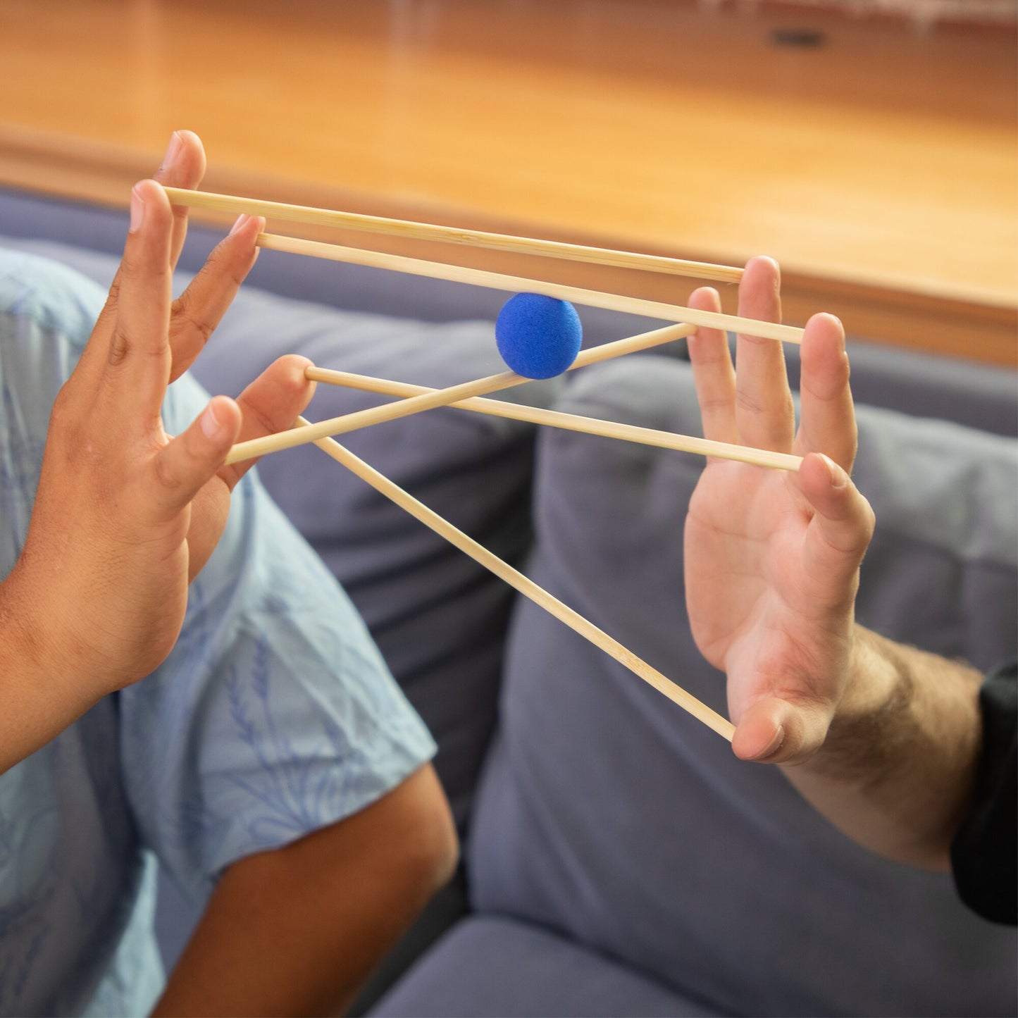 KESS Yubibo cooperative game with two players holding wooden sticks and blue ball, skill and balance toy