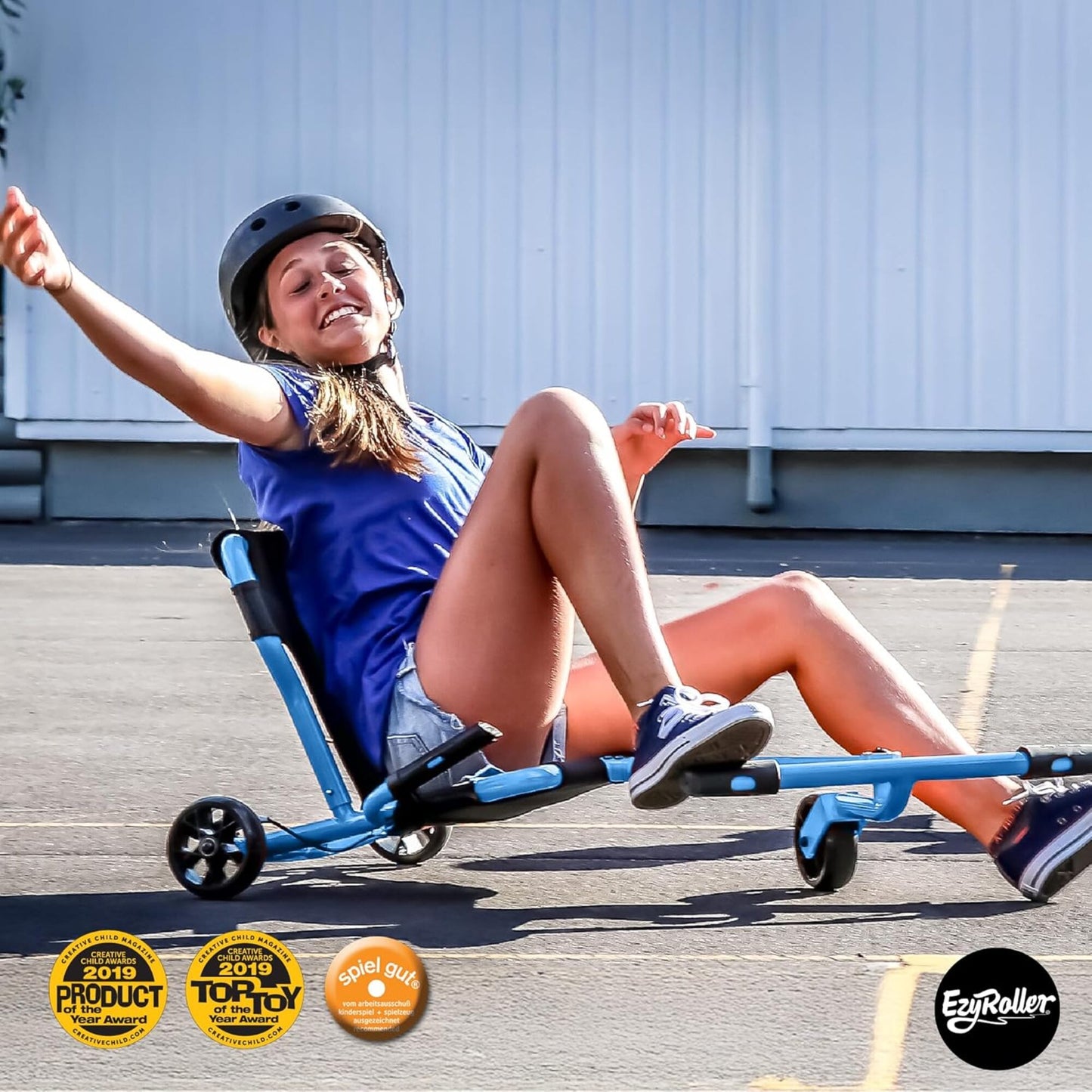EzyRoller Pro X blue pedal-free ride-on with hand brakes, girl riding on pavement