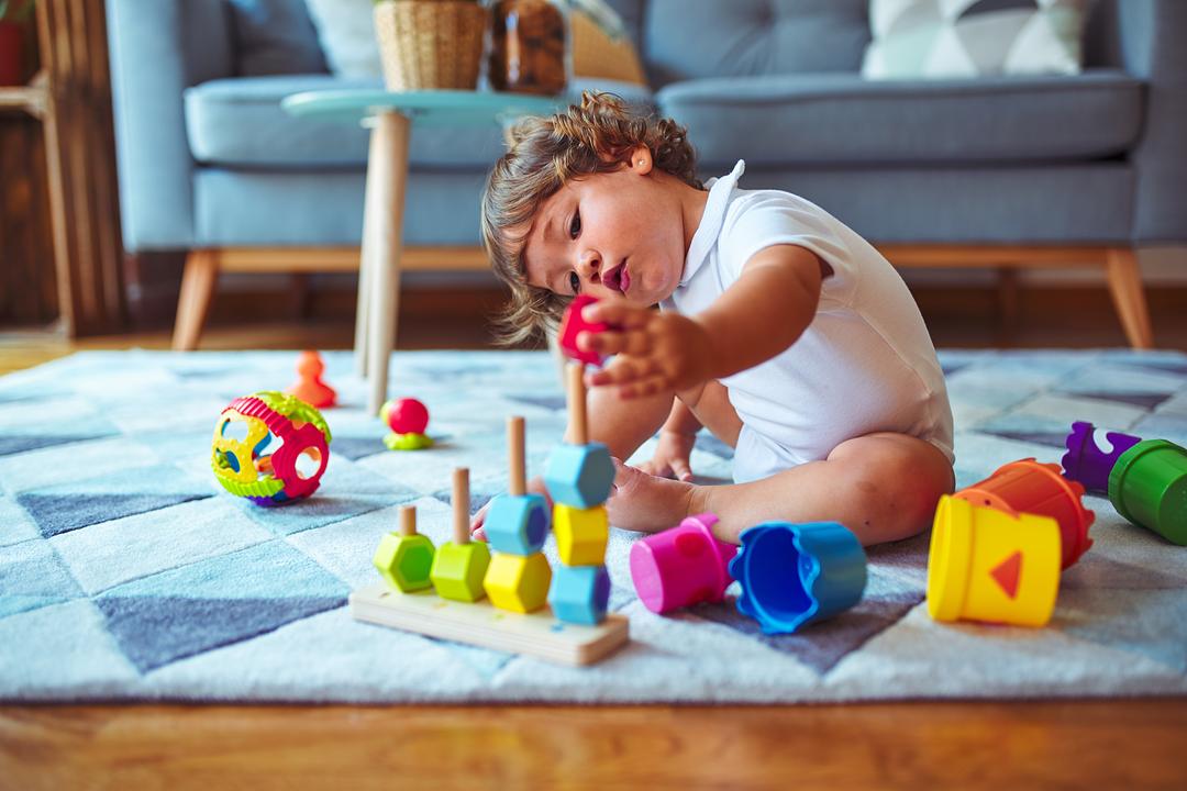 Toddler playing with stacking toy