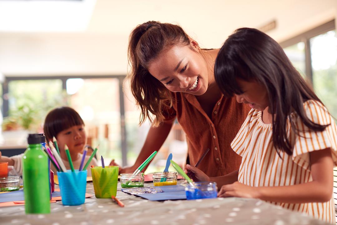 Mom and kids coloring with colored pencils