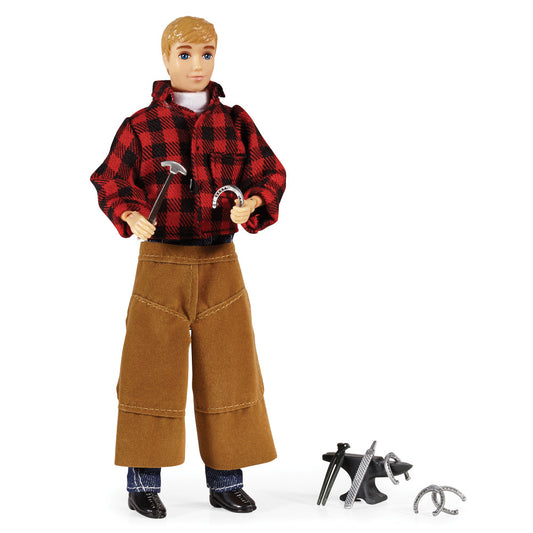 Articulated male action figure with blonde hair wearing red plaid jacket and tan pants, holding blacksmith tools; includes hammer, anvil, horseshoe, and other m