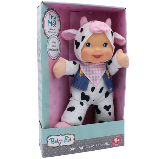 Baby's First Singing Farm Friends cow doll in packaging with pink ears, white and black spotted body, pink gingham bandana, and denim vest