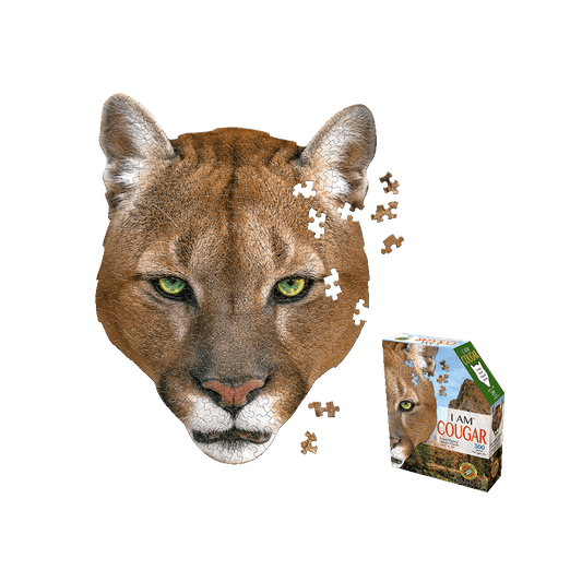Madd Capp I AM COUGAR Jigsaw Puzzle showing cougar head-shaped puzzle with green eyes and scattered pieces, with product box displayed on right