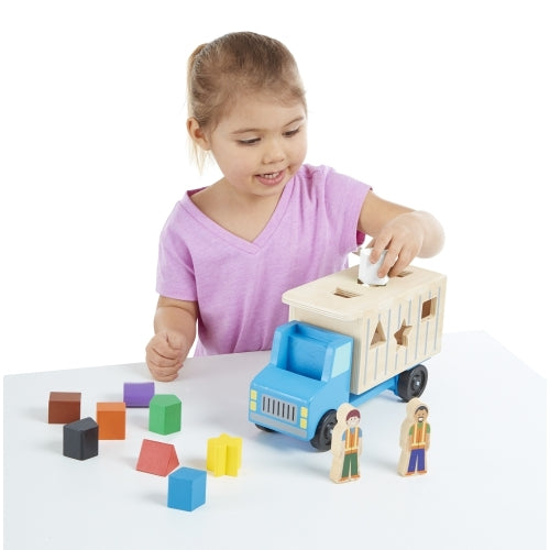Dump Truck toy with blue cab, beige cargo bed, colorful building blocks, and two character figures