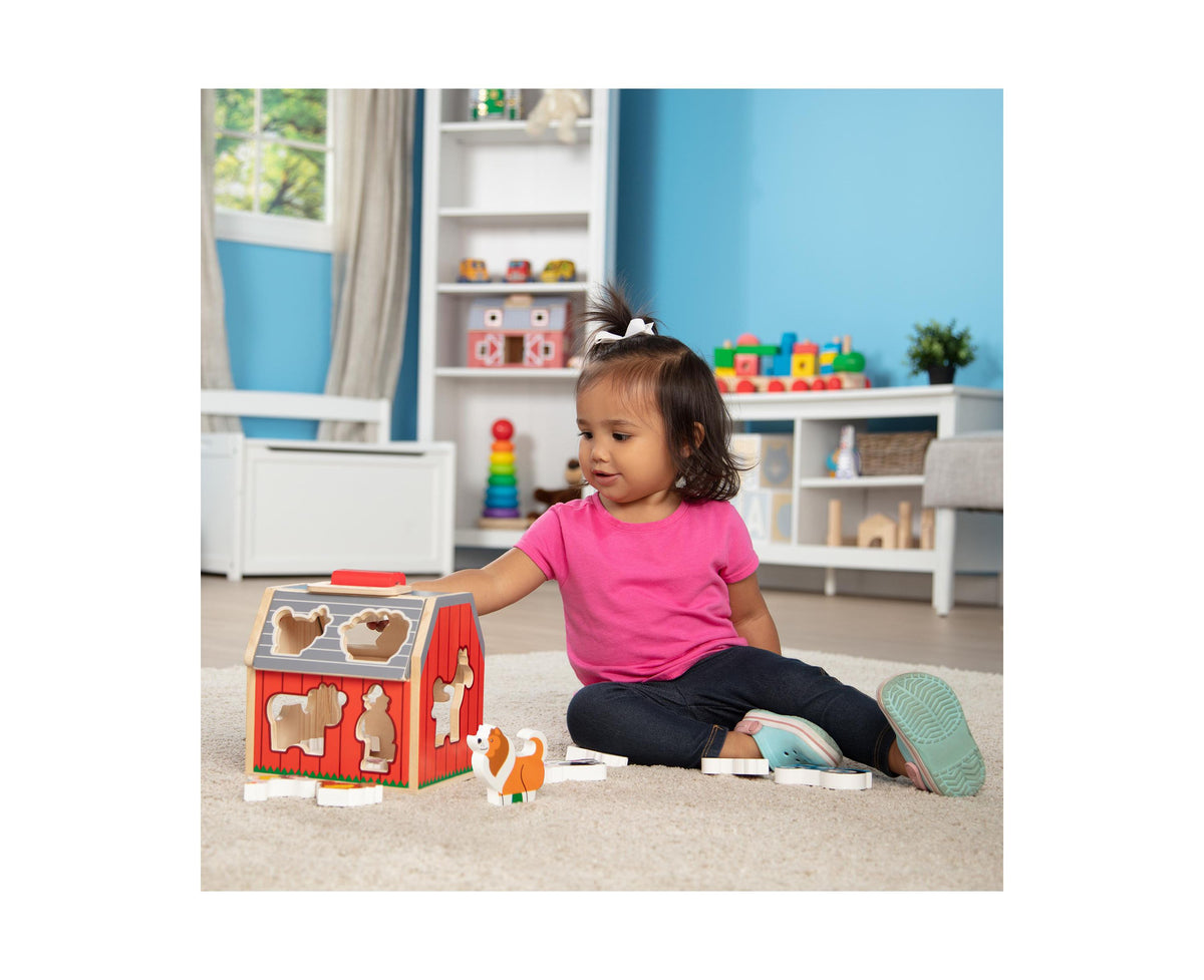 Melissa & Doug Take-Along Sorting Barn with toddler playing with farm animal pieces on carpet