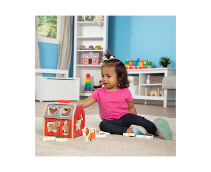 Melissa & Doug Take-Along Sorting Barn with toddler playing with farm animal pieces on carpet