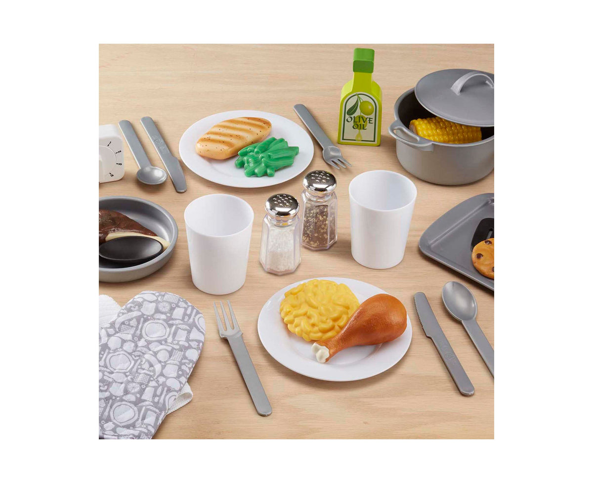 Melissa & Doug 22-Piece Play Kitchen Accessories Set with pot, pan, plates, cups, and silverware displayed on wooden ...