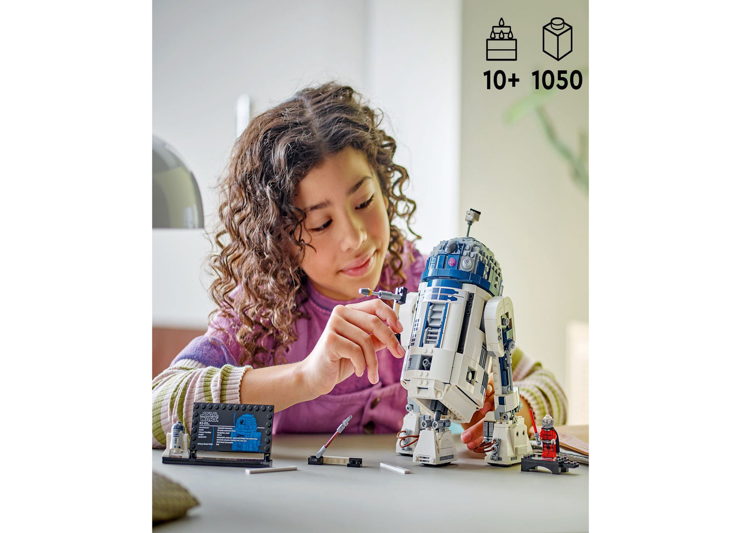 Girl building LEGO Star Wars R2-D2 1050-piece buildable figure with blue and white droid