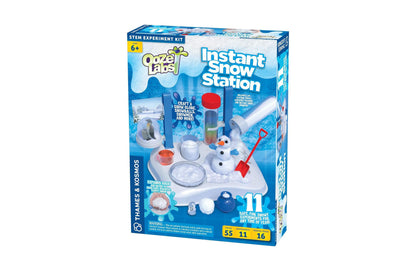 Thames and Kosmos Ooze Labs Instant Snow Station STEM kit with white base station, snowman figure, red shovel, and bl...