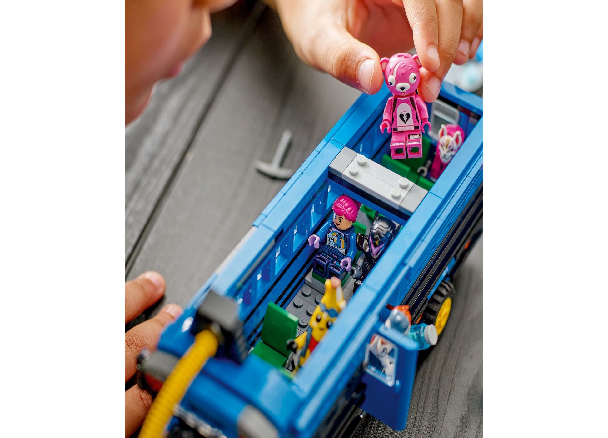 LEGO Fortnite Battle Bus toy with pink minifigure being placed inside blue vehicle