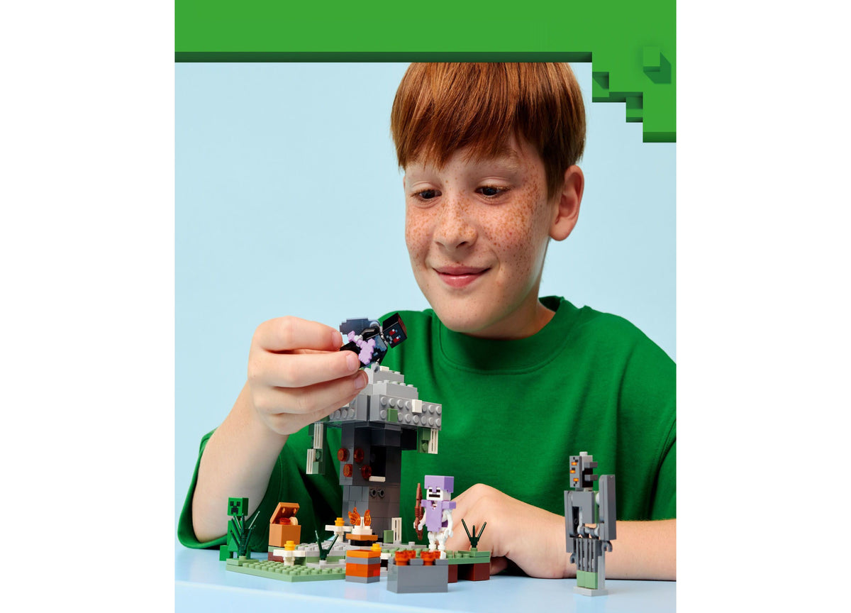 Child building LEGO Minecraft The Pale Garden set with Mothman minifigure, gray landscape, and tree structure