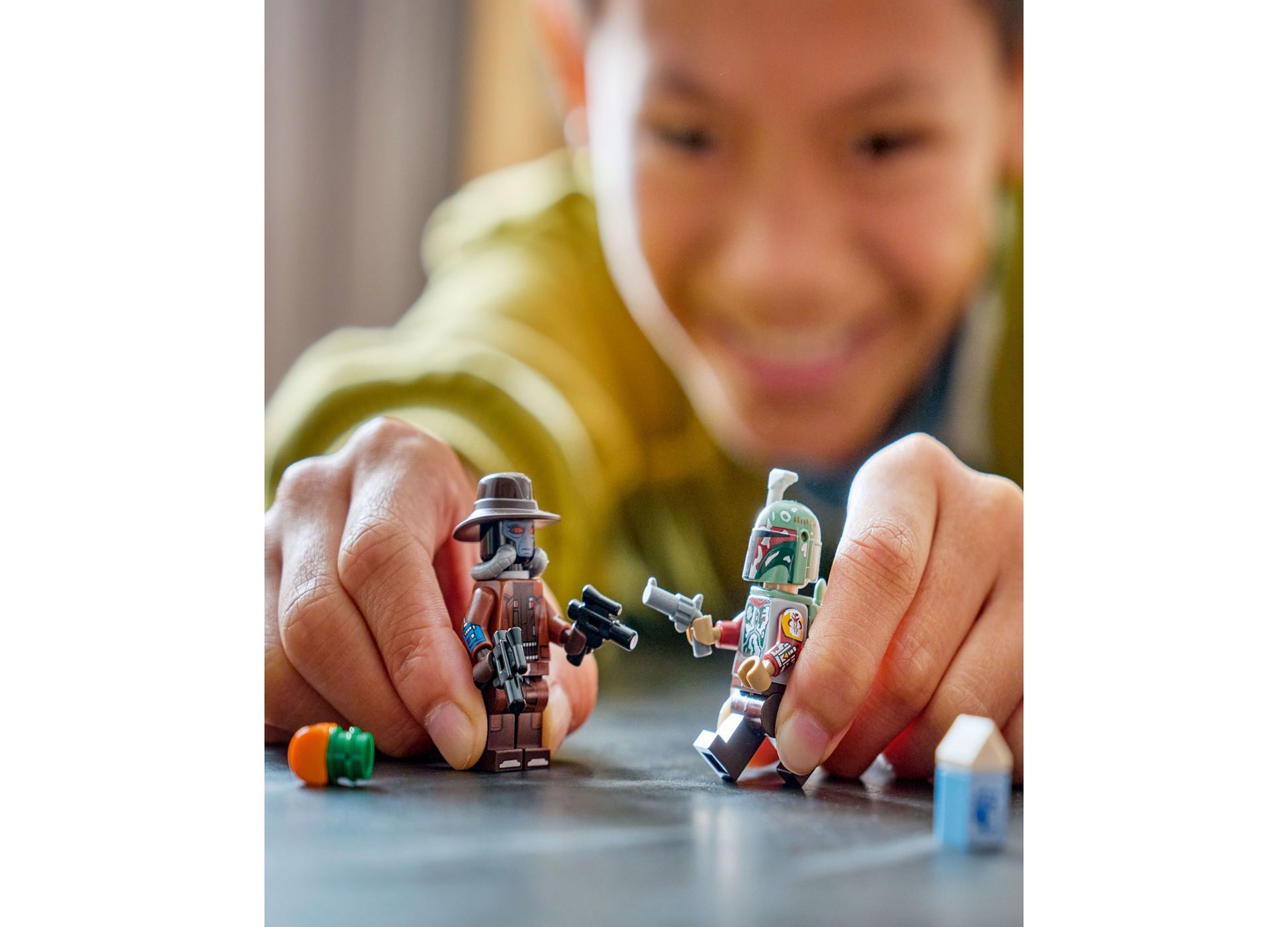 Child playing with LEGO Star Wars Cobb Vanth's Speeder building toy set with minifigures