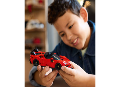Child holding red LEGO Speed Champions Ferrari SF90 sports car building toy