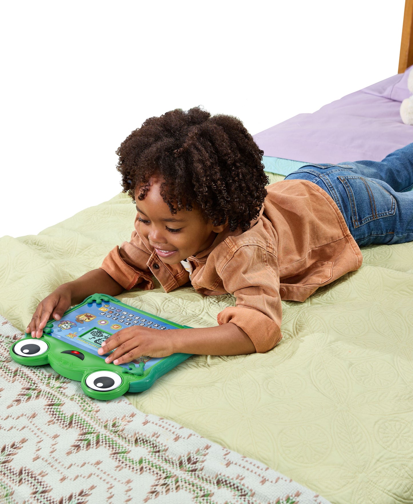 Child playing with green Leapfrog Toy Story Lilypad Learning Pad on bed