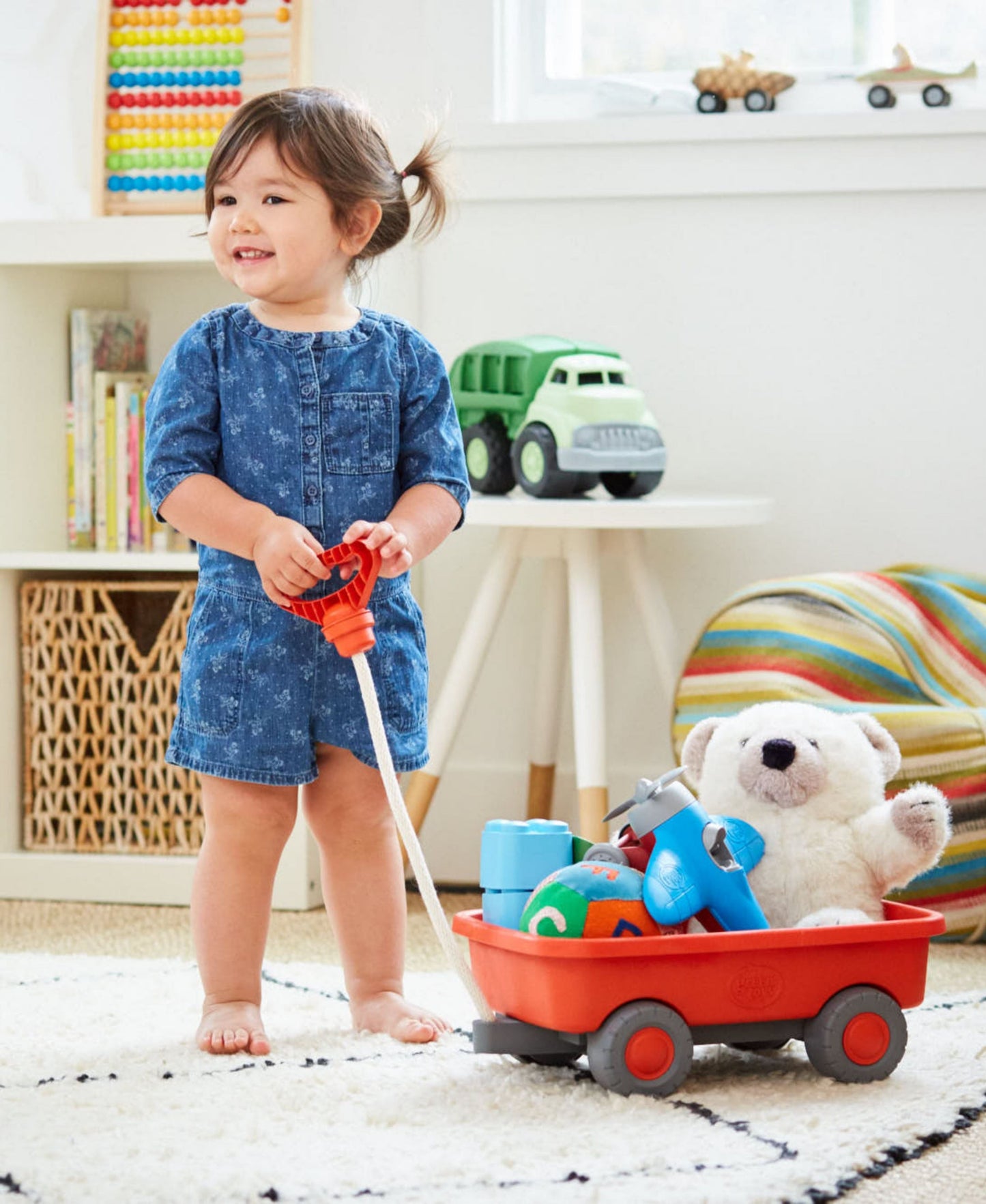 Green Toys Wagon Orange with child pulling toys in playroom