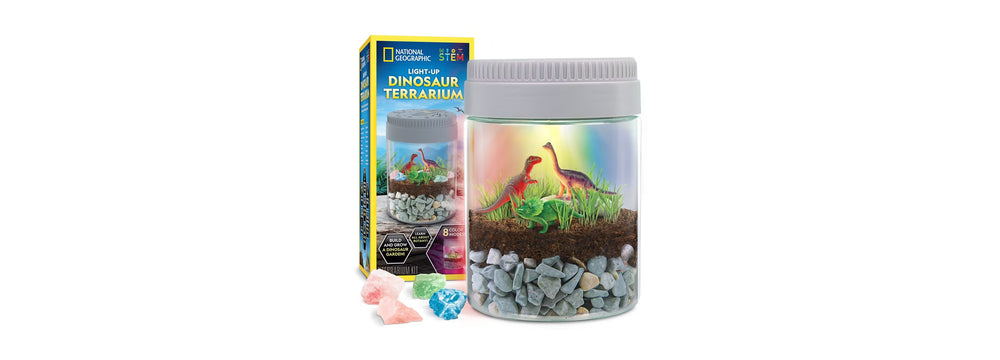 National Geographic Light-Up Dinosaur Terrarium Kit with illuminated jar, dinosaur figurines, and colored crystals