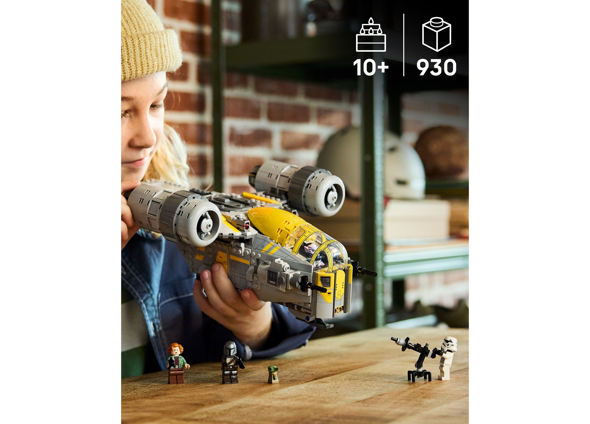 Child holding LEGO Star Wars The Razor Crest 75447 yellow and gray starship building set with minifigures