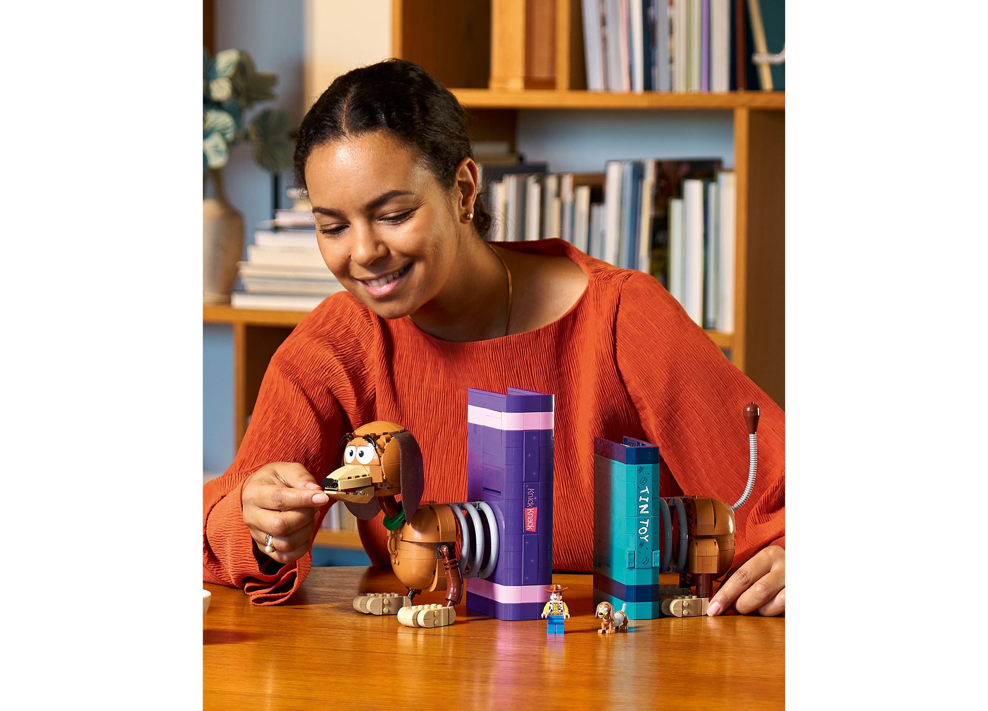 Girl playing with LEGO Disney Toy Story Slinky Dog Bookends set with purple and teal containers