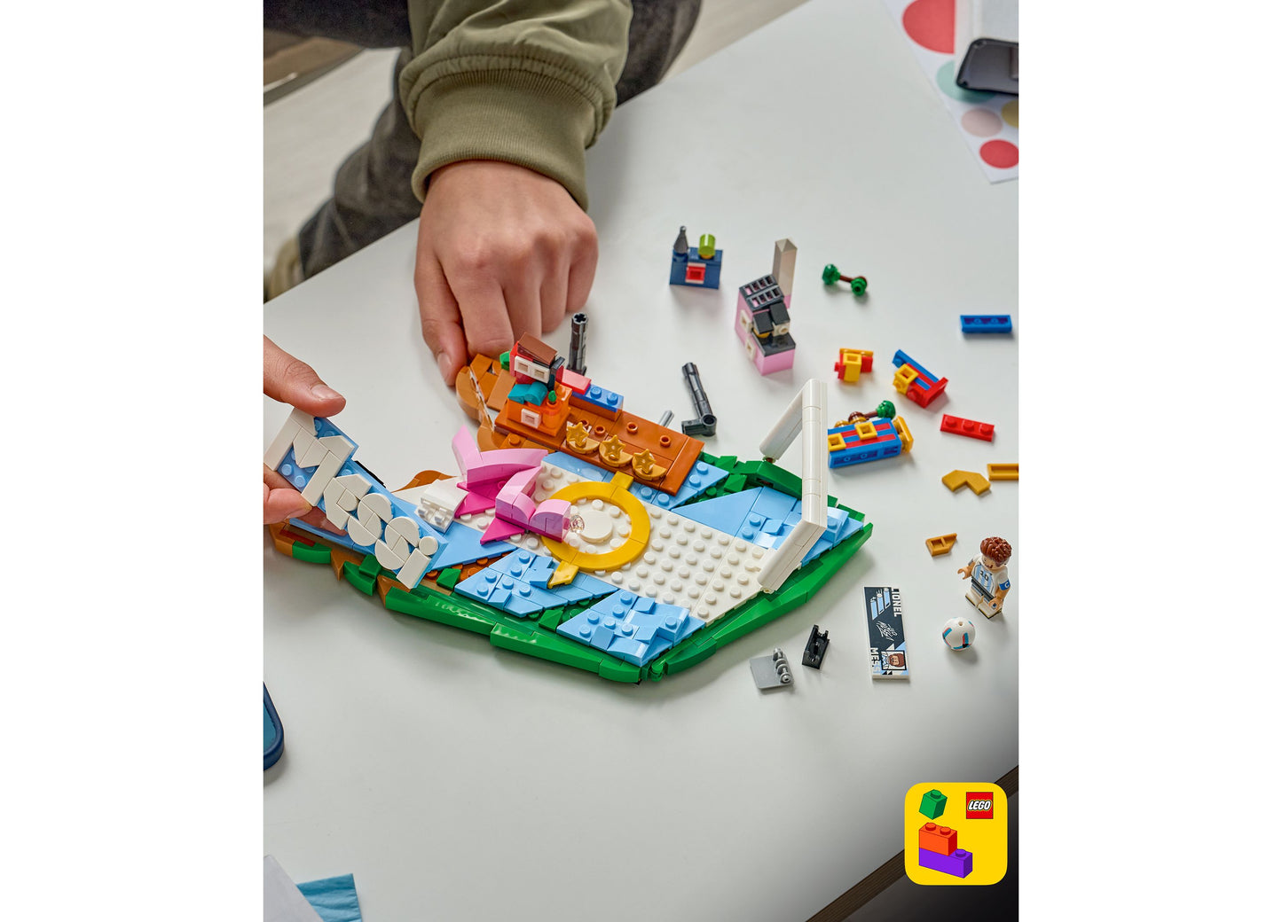 LEGO Editions Lionel Messi Soccer Highlights 43011 set with 500 pieces being built, featuring colorful blue, orange, ...
