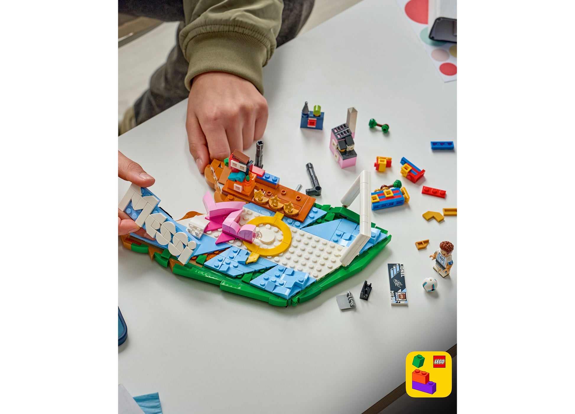 LEGO Editions Lionel Messi Soccer Highlights 43011 set with 500 pieces being built, featuring colorful blue, orange, ...