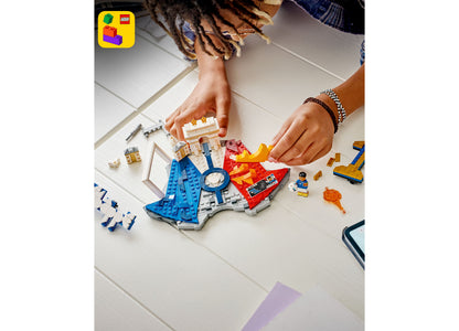 LEGO Kylian Mbappé Soccer Highlights 43013 set with blue, red, and white pieces being assembled by hands on white sur...