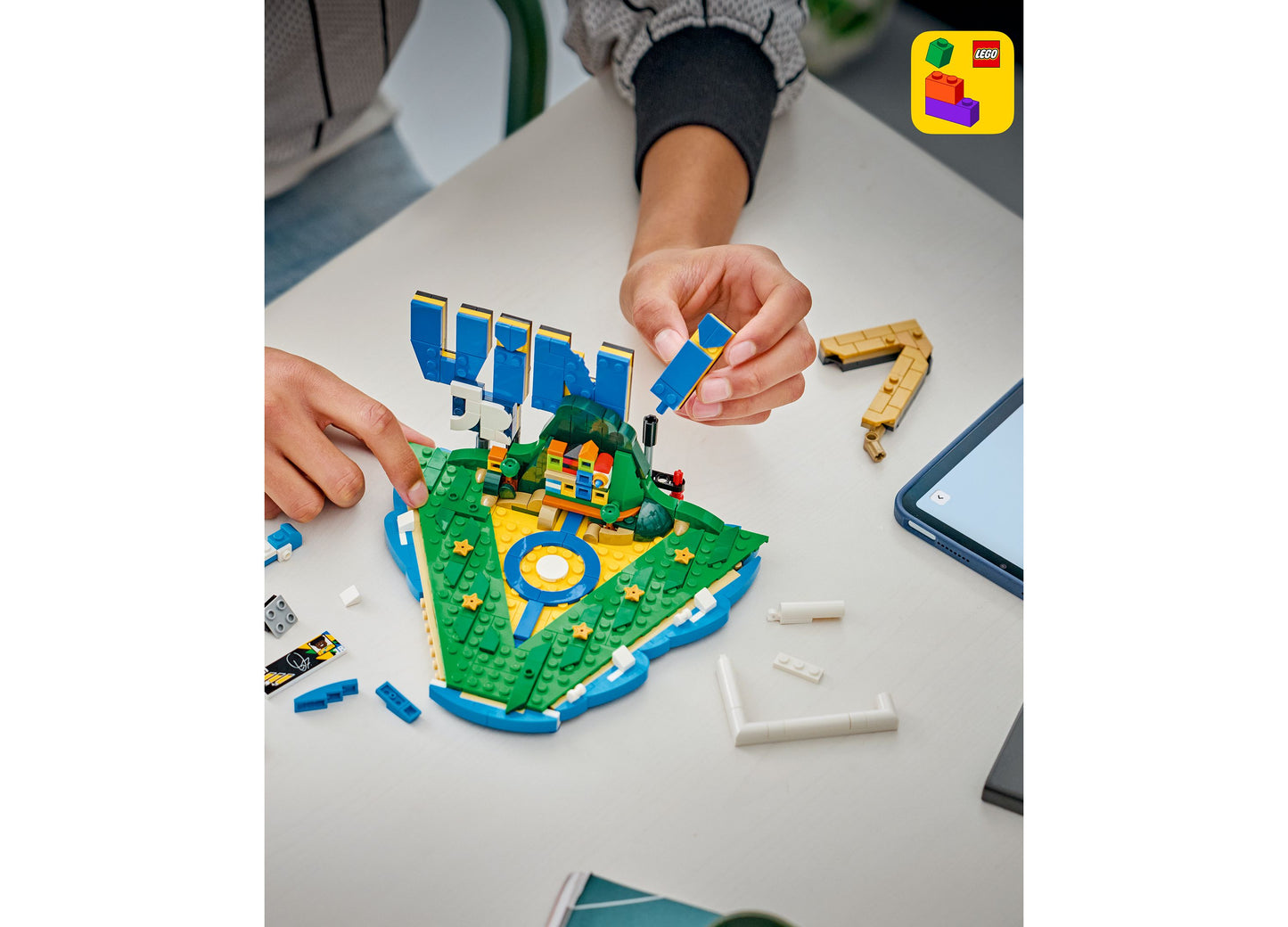 LEGO Editions Vini Jr. Soccer Highlights 43027 set being built with blue, green, and yellow pieces on white table