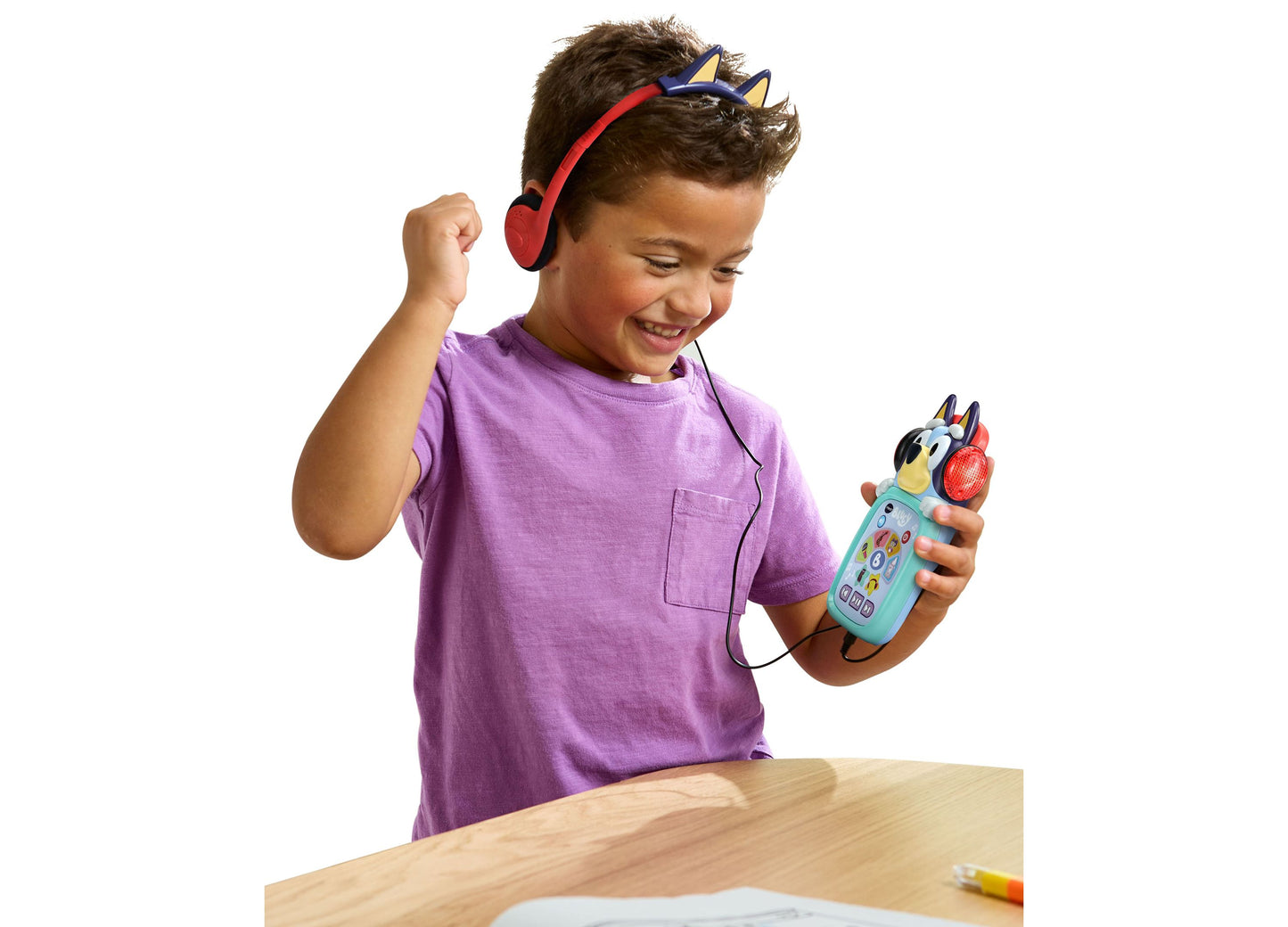 Child wearing red headphones playing Bluey VTech Musical Moments Player toy in turquoise and red