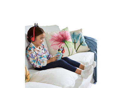 Girl wearing red headphones playing with Bluey VTech Musical Moments Player on bed