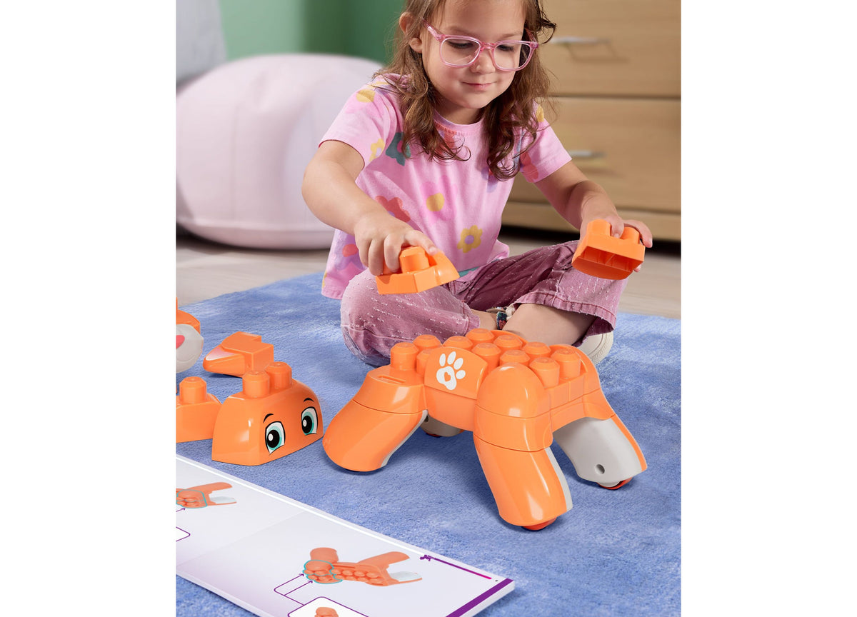 Child building orange Mega Bloks Fisher-Price Rolling Kitten 3-in-1 set with instruction card