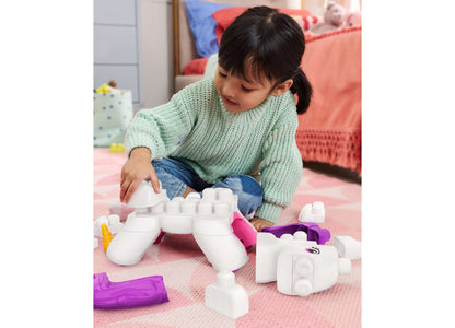 Child playing with white and purple Mega Bloks Build & Enchant Unicorn 26-Piece Building Set on pink mat