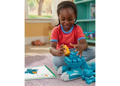 Child playing with blue and yellow Mega Bloks dinosaur building set with rolling wheels on purple mat