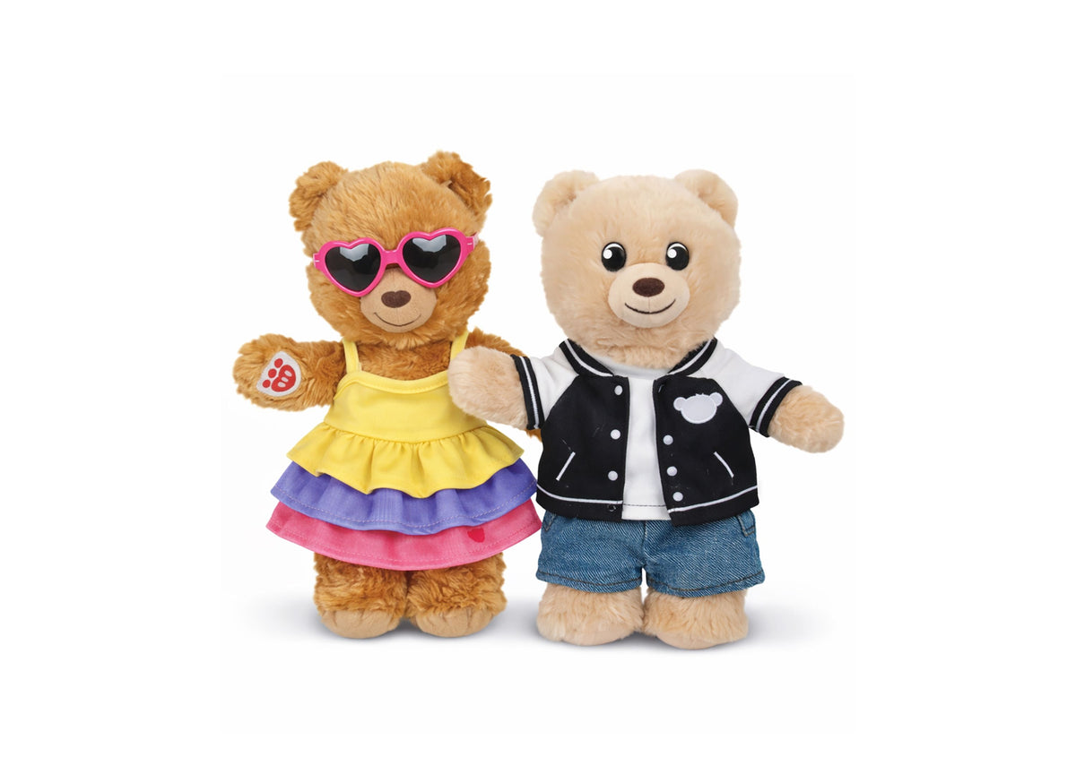 Two Build-A-Bear Workshop mini bears dressed in colorful outfits - one in a yellow, purple and pink skirt with heart-...