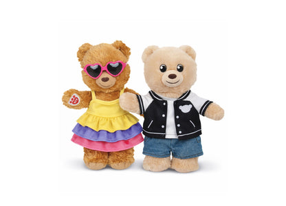 Two Build-A-Bear Workshop mini bears dressed in colorful outfits - one in a yellow, purple and pink skirt with heart-...