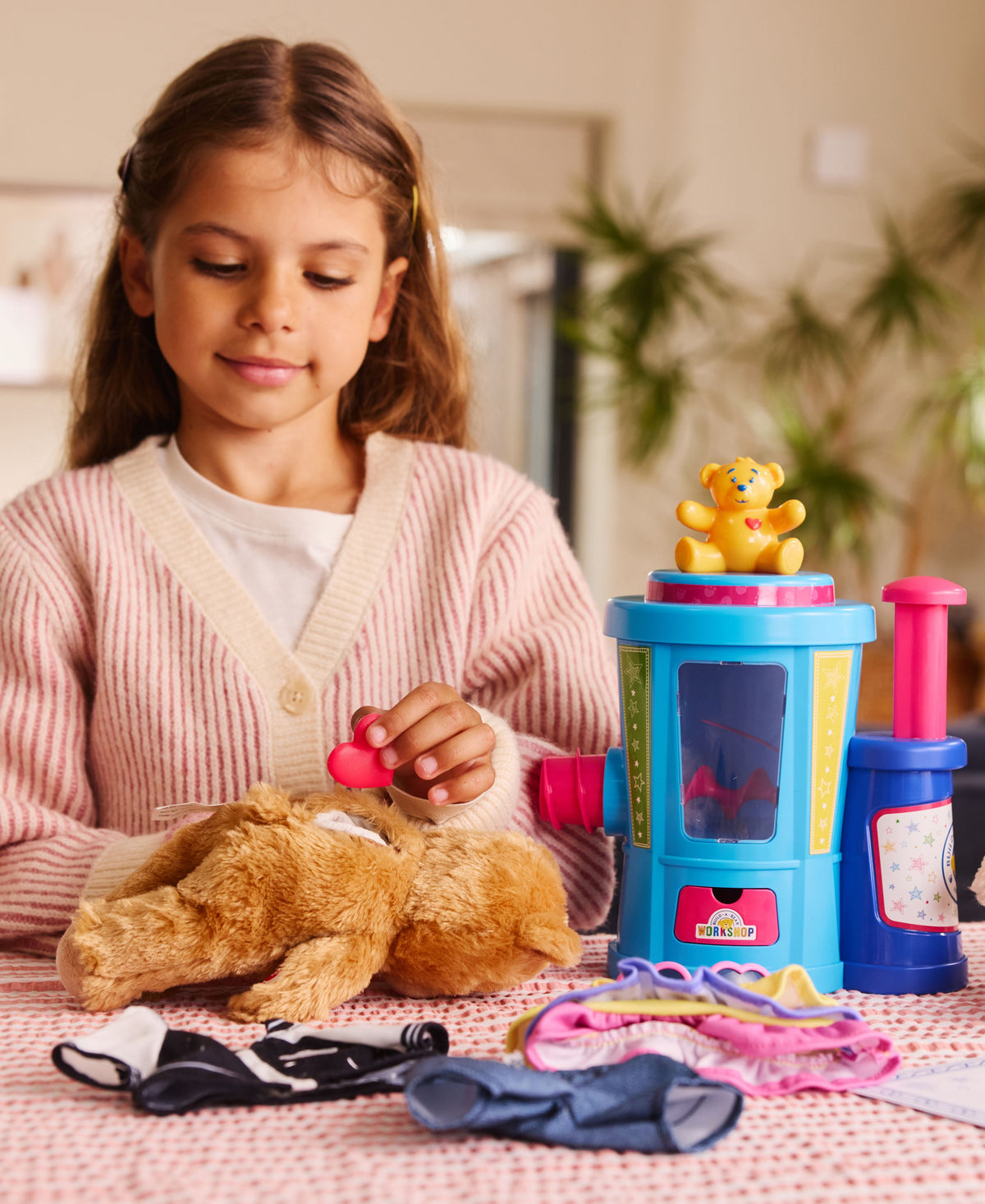 Casdon Build-A-Bear Workshop Stuffing Station playset with yellow bear character and colorful blue station