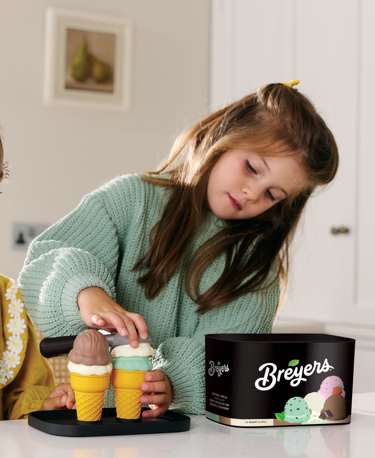 Casdon Breyers Ice Cream Scoop-and-Serve playset with child holding colorful cone scoops and black tub