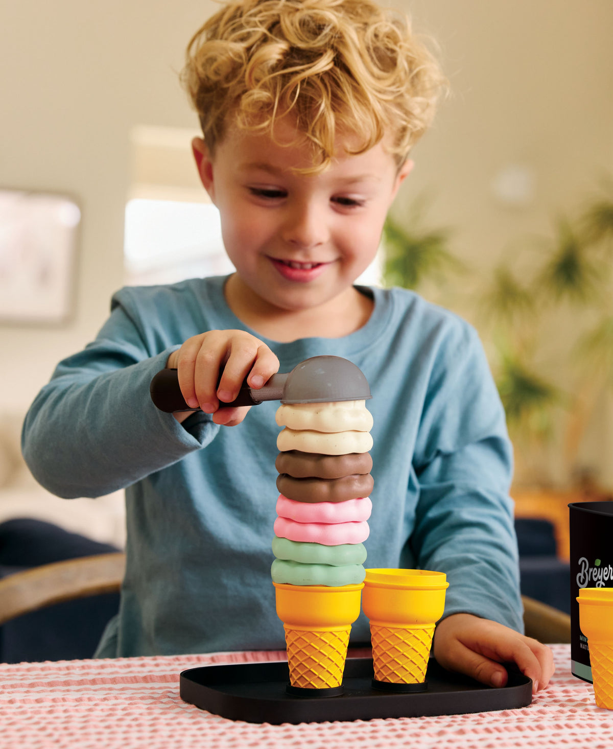 Child stacking colorful ice cream scoops on cone with Casdon Breyers Ice Cream Scoop-and-Serve Playset