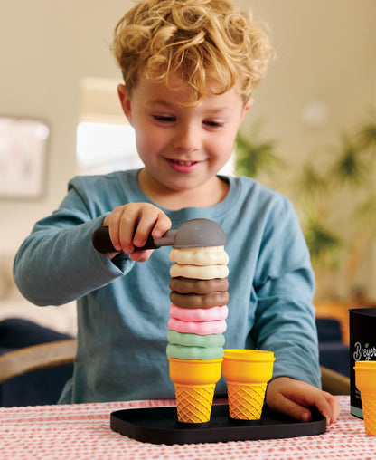Child stacking colorful ice cream scoops on cone with Casdon Breyers Ice Cream Scoop-and-Serve Playset