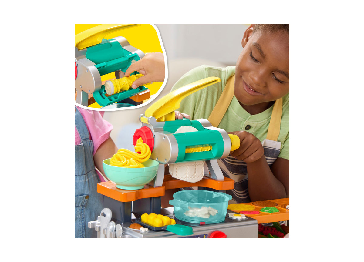 Child using Play-Doh Super Sizzlin Kitchen Playset with green and yellow pasta maker, creating yellow noodles into tu...