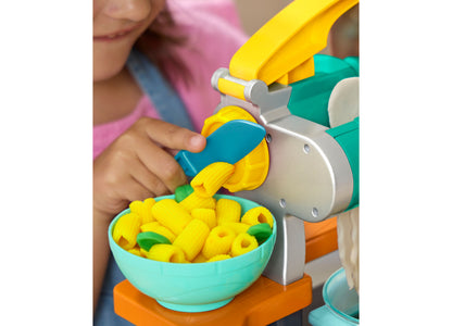 Child using Play-Doh Super Sizzlin Kitchen Playset with yellow pasta maker tool and turquoise bowl of yellow play dou...