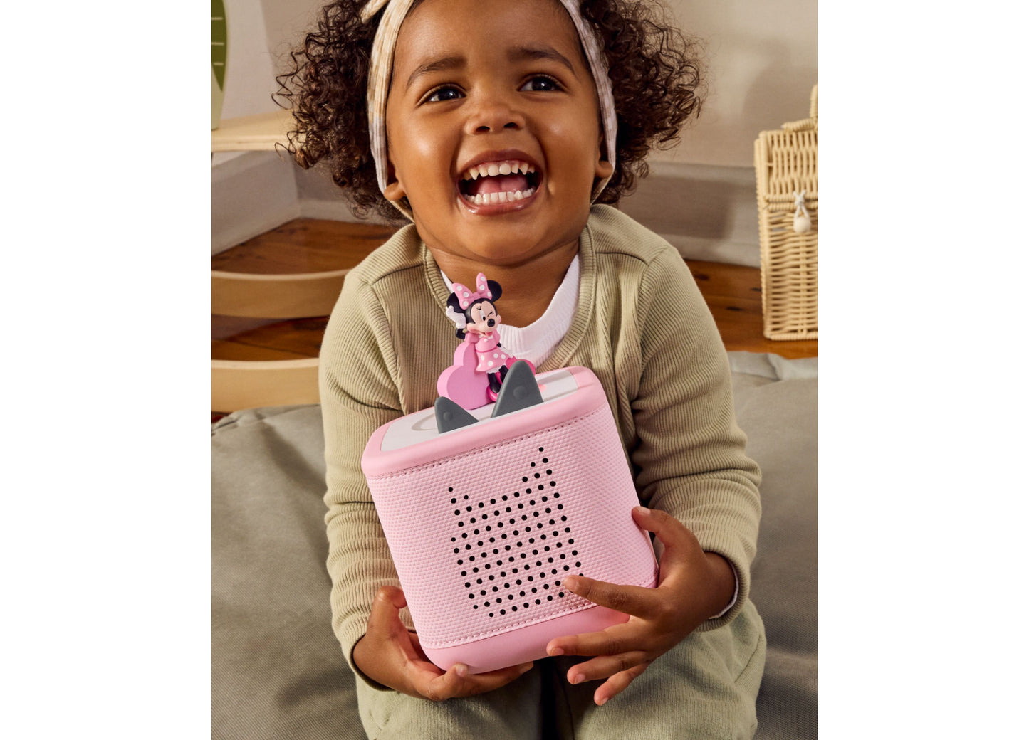 Tonies Minnie Mouse Clubhouse pink Tonie figurine with speaker grille, displayed by smiling child