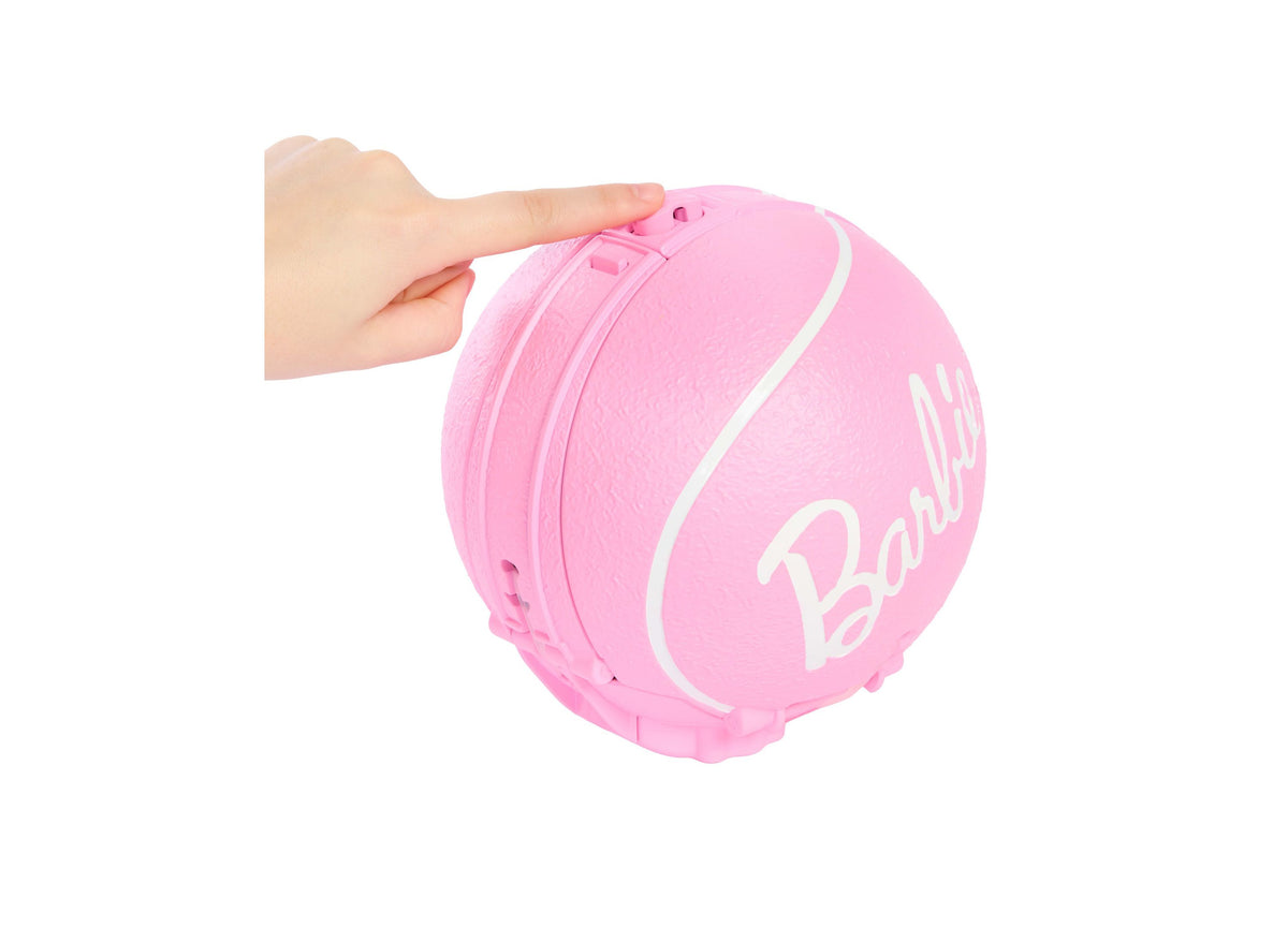 Pink Barbie tennis ball with white logo and stripes, held by child's hand
