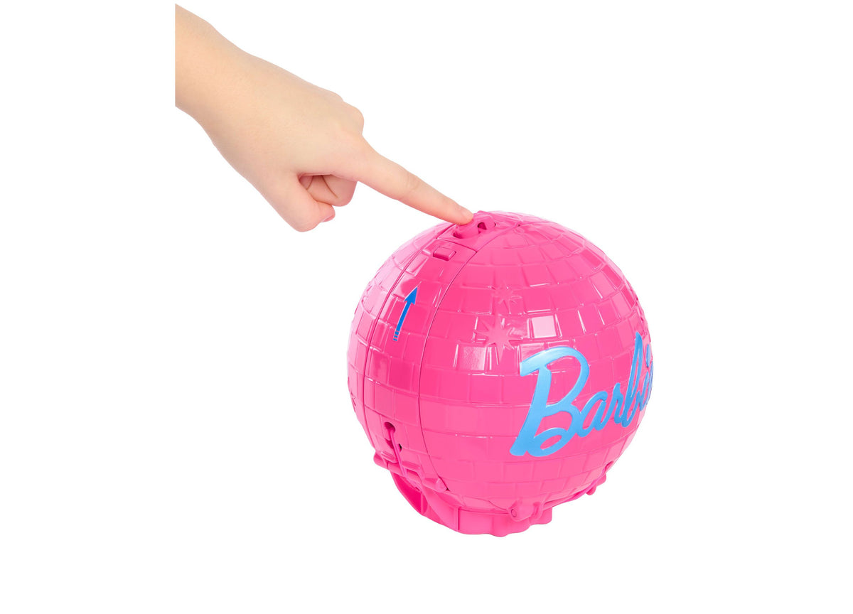 Bright pink Barbie Pop Star ball with blue Barbie logo text, held by a child's hand against white background