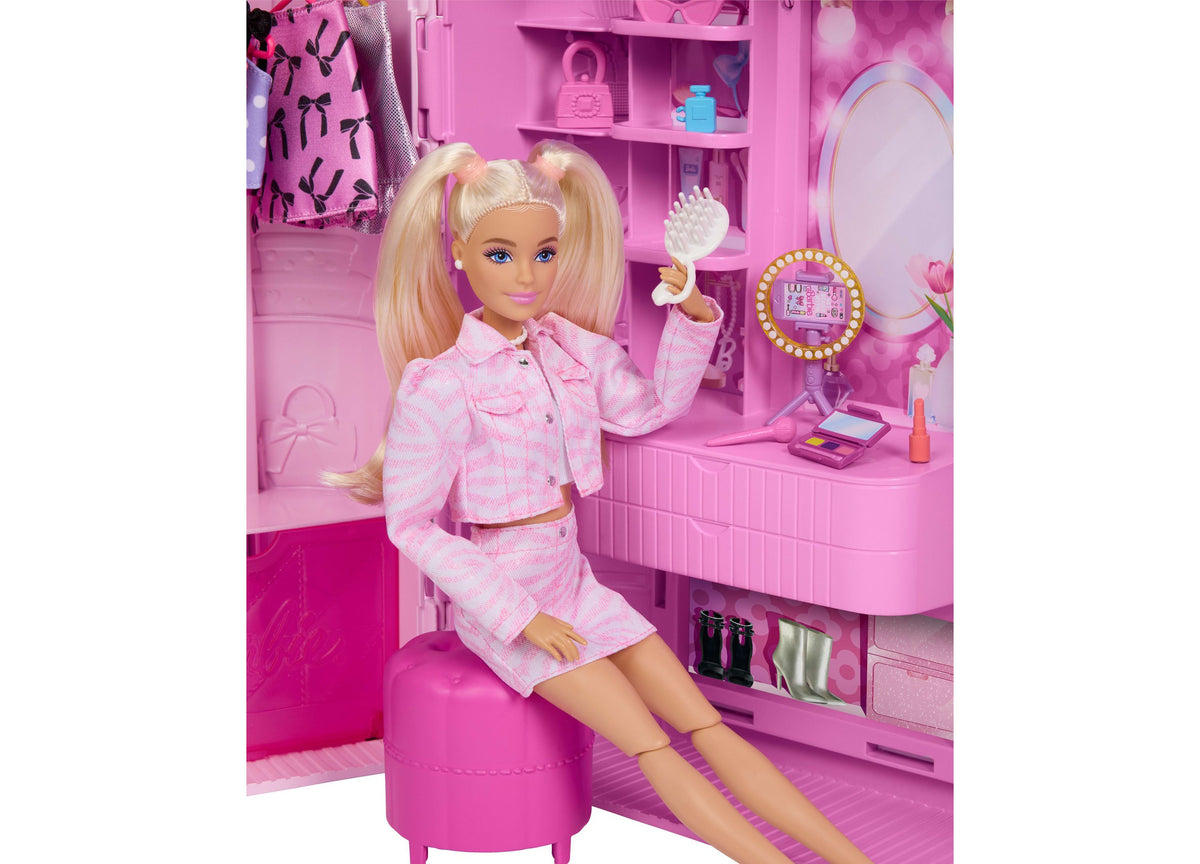 Barbie Deluxe Style Closet playset with blonde doll in pink checkered outfit sitting in front of pink closet organize...