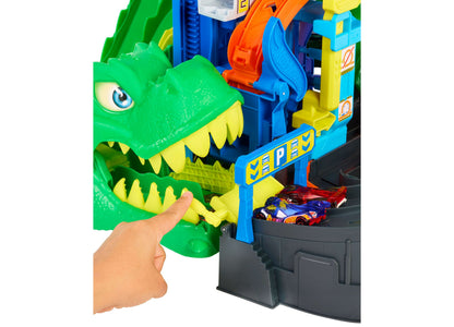 Hot Wheels T-Rex Garage Playset with green dinosaur head, colorful track, and die-cast cars